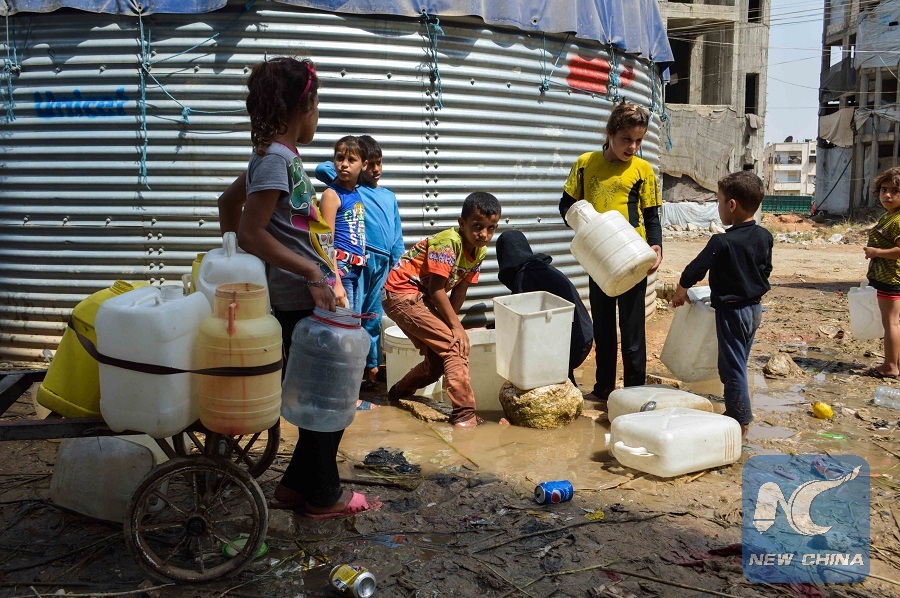 (150804) -- ALEPPO, Aug. 4, 2015 (Xinhua) -- Syrian children fill plastic containers with drinking water in Aleppo city, Syria, on Aug. 4, 2015. Child labor has become rampant in Aleppo. Children in Aleppo are increasingly working on collecting plastic and hard paper to sell in order to help their conflict-weary parents. (Xinhua/Abd Fayad)