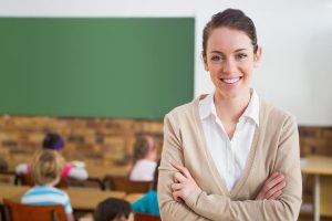 bigstock-pretty-teacher-smiling-at-came-69887626