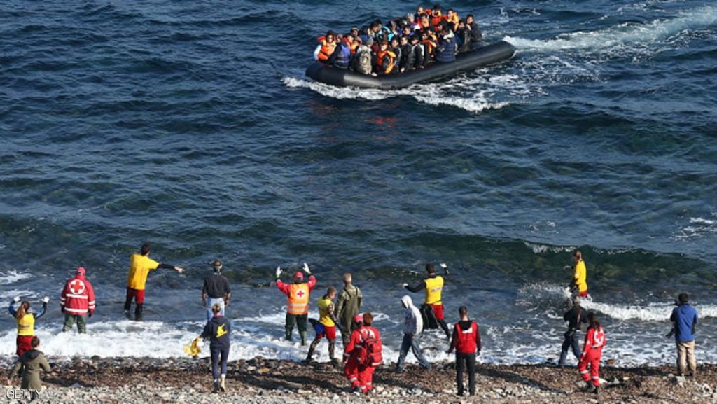 SIKAMINIAS, GREECE - NOVEMBER 17: Aid workers gesture at a migrant boat as it approaches shore after making the crossing from Turkey to the Greek island of Lesbos on November 17, 2015 in Sikaminias, Greece. Rafts and boats continue to make the journey from Turkey to Lesbos each day as thousands flee conflict in Iraq, Syria, Afghanistan and other countries. Over 500,000 migrants have entered Europe so far this year and approximately four-fifths of those have paid to be smuggled by sea to Greece from Turkey, the main transit route into the EU. Most of those entering Greece on a boat from Turkey are from the war zones of Syria, Iraq and Afghanistan. (Photo by Carl Court/Getty Images)