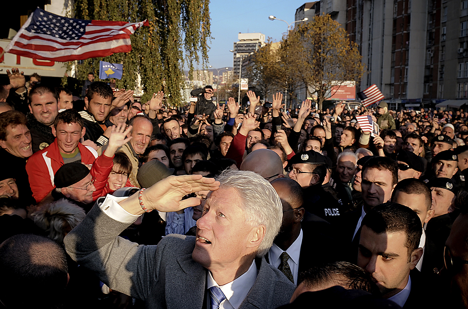 Former US President Bill Clinton (C, front) gestures as he greets Kosovo citizens during his visit in Pristina on November 1, 2009. Kosovo Albanians, who admire Clinton because of his role in the 1999 NATO bombings of then Yugoslavian President Slobodan Milosevic, honoured him by erecting a three-metre (10-feet) tall monument on a Pristina boulevard already named after him. AFP PHOTO/ARMEND NIMANI (Photo credit should read Armend Nimani/AFP/Getty Images)