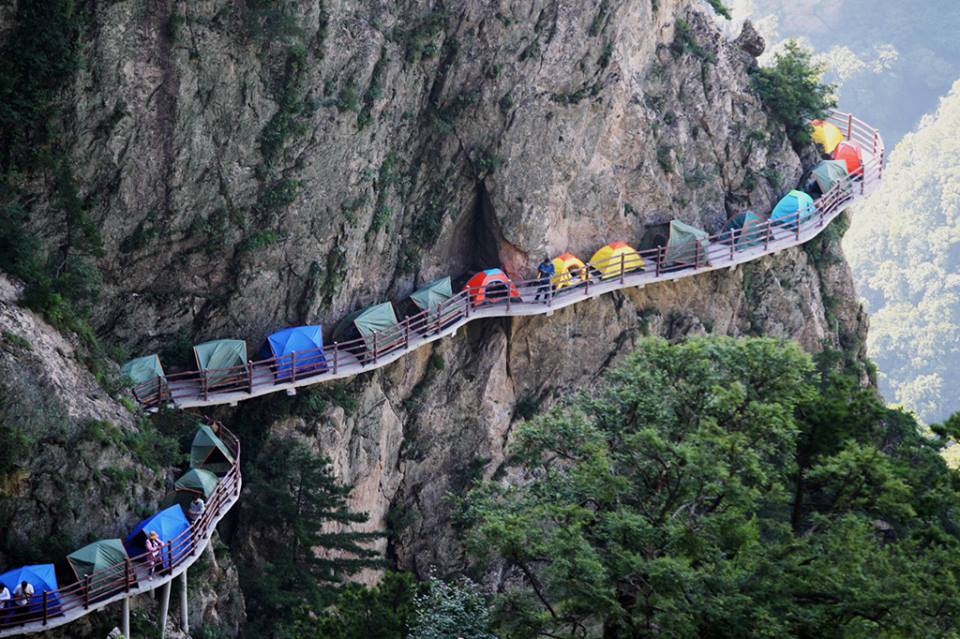 campers-setting-up-tents-on-a-narrow-walkway-hanging-1000-meters-on-the-cliff-of-laojun-mountain-in-china-1