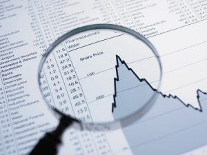 Magnifying glass and descending line graph and list of share prices