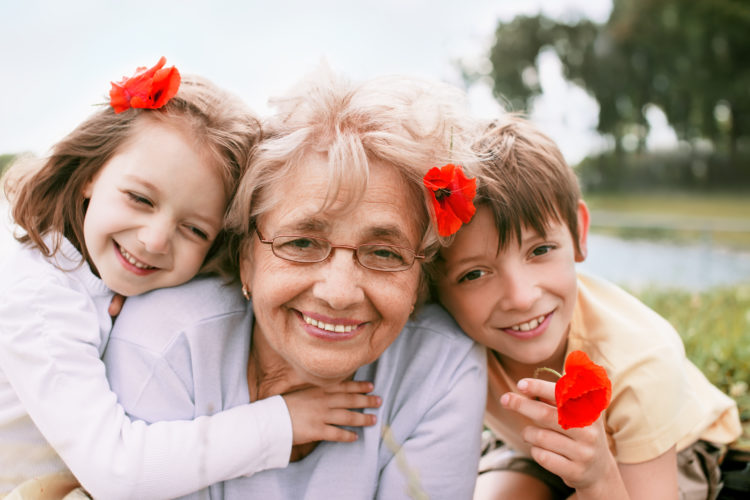 Closeup summer portrait of happy grandmother with grandchildren outdoors