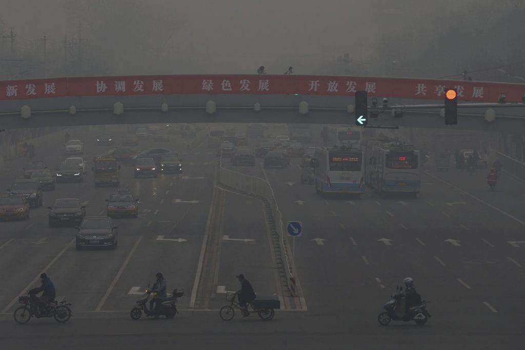 WU09 PEKÍN (CHINA) 22/12/2015 Coches circulan por una de las principales avenidas de Pekín en medio de una fuerte niebla causada por la contaminación hoy, 22 de diciembre de 2015. Pekín permanece en alerta roja desde el pasado día 18 cuando puso en marcha un protocolo de actuación que incluye el cierre de colegios y la recomendación a los vecinos para que permanezcan en espacios cerrados.EFE/Wu Hong